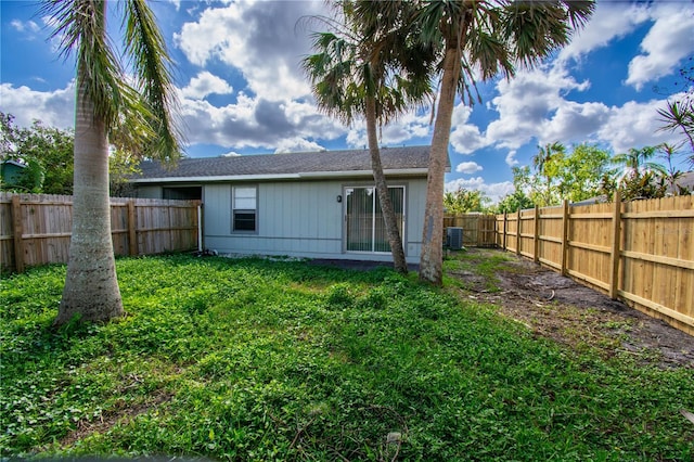 back of property featuring a lawn and central air condition unit