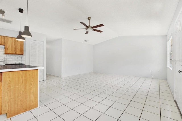 kitchen featuring tasteful backsplash, vaulted ceiling, ceiling fan, light tile patterned floors, and hanging light fixtures