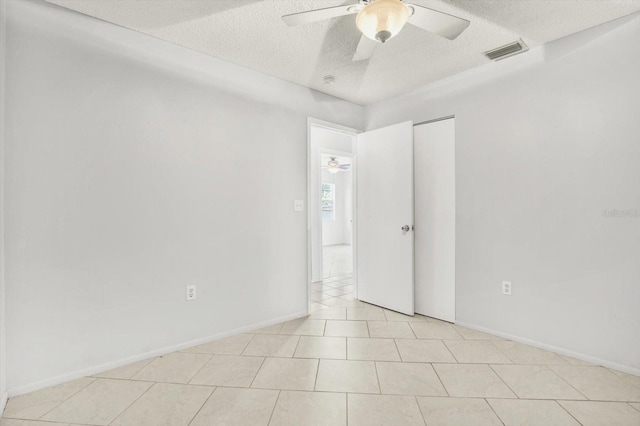 tiled spare room featuring ceiling fan and a textured ceiling