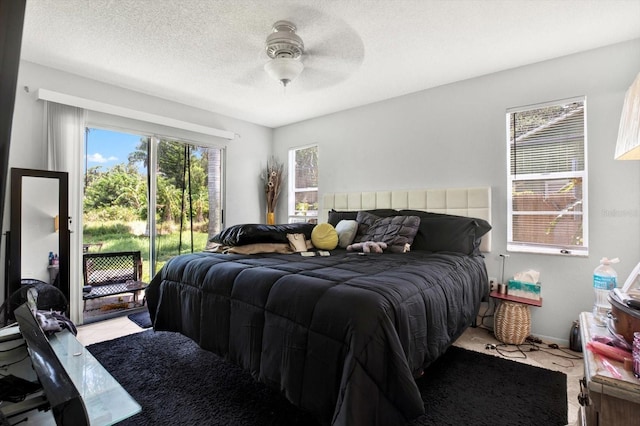 bedroom featuring access to outside, ceiling fan, and a textured ceiling