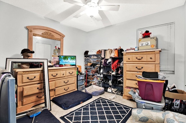 interior space with light tile patterned floors, a textured ceiling, and ceiling fan