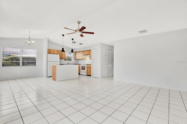 kitchen with tasteful backsplash, white appliances, pendant lighting, a kitchen island, and lofted ceiling