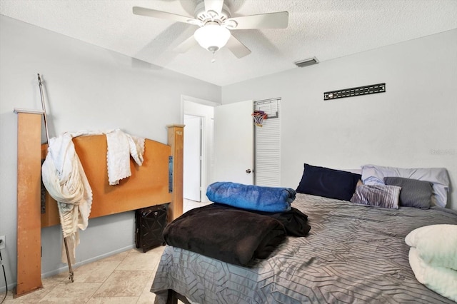 tiled bedroom featuring ceiling fan and a textured ceiling