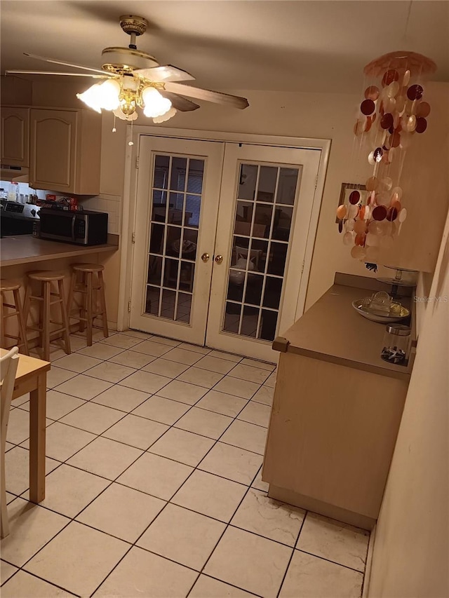 interior space with ceiling fan, french doors, and light tile patterned floors