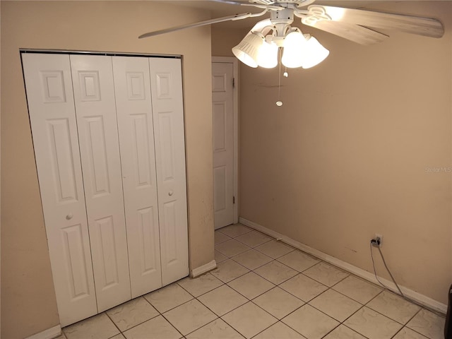 unfurnished bedroom featuring ceiling fan, light tile patterned floors, and a closet