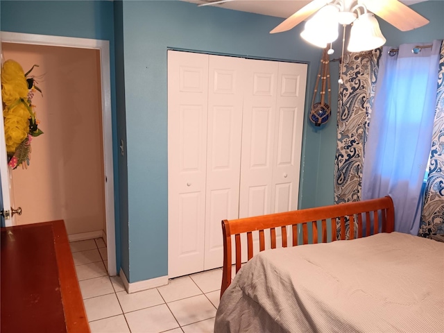 tiled bedroom with ceiling fan and a closet