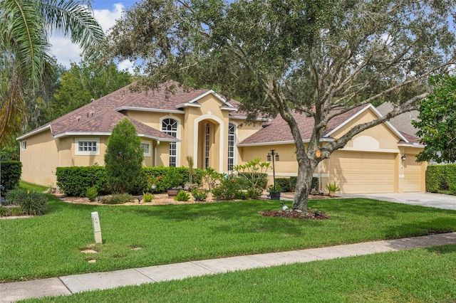 mediterranean / spanish-style home with a front yard and a garage