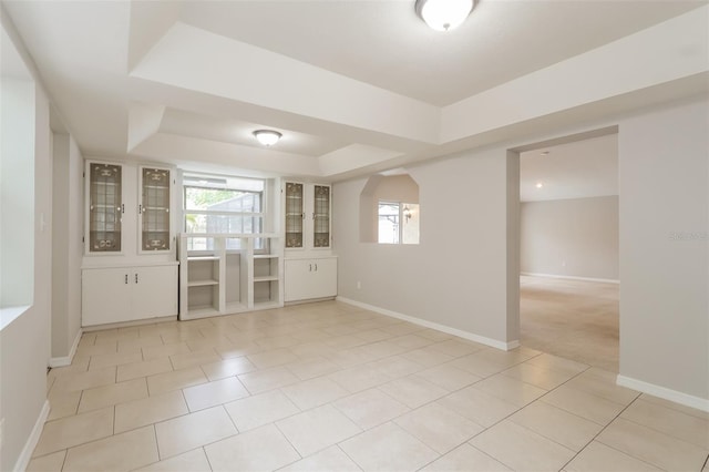 spare room with light tile patterned flooring and a tray ceiling