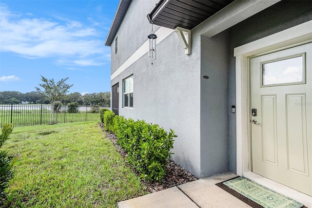 property entrance featuring a lawn