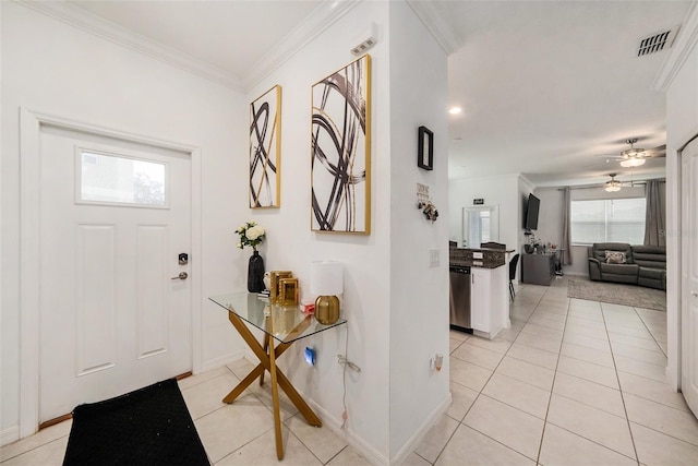 tiled entrance foyer featuring ceiling fan and crown molding