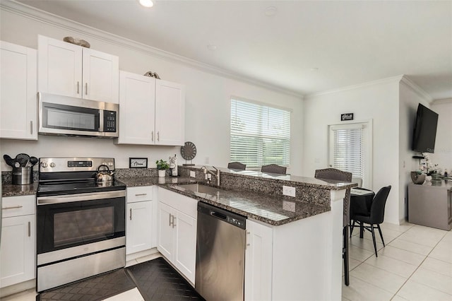 kitchen with ornamental molding, sink, kitchen peninsula, white cabinetry, and appliances with stainless steel finishes