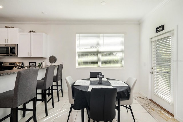 dining space featuring a healthy amount of sunlight, crown molding, and light tile patterned floors