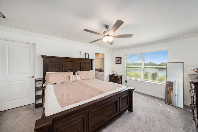 bedroom featuring ornamental molding, light carpet, ceiling fan, and ensuite bath