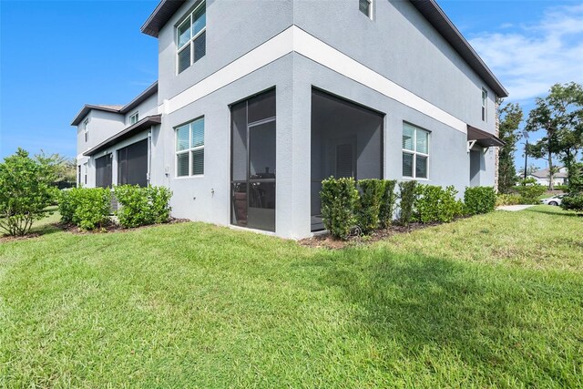 back of property with a sunroom and a yard