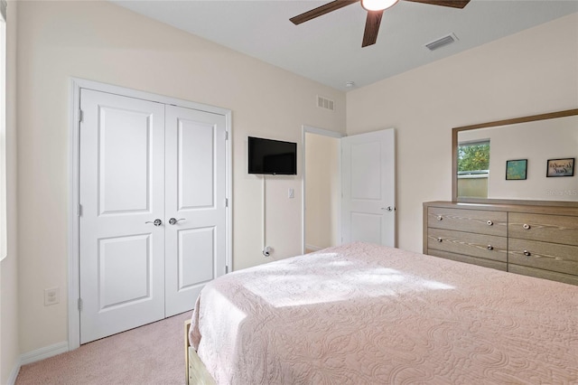 carpeted bedroom featuring ceiling fan and a closet