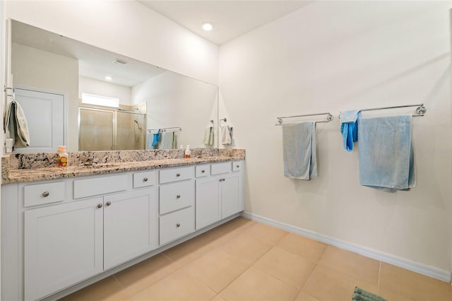 bathroom with tile patterned flooring, vanity, and a shower with door