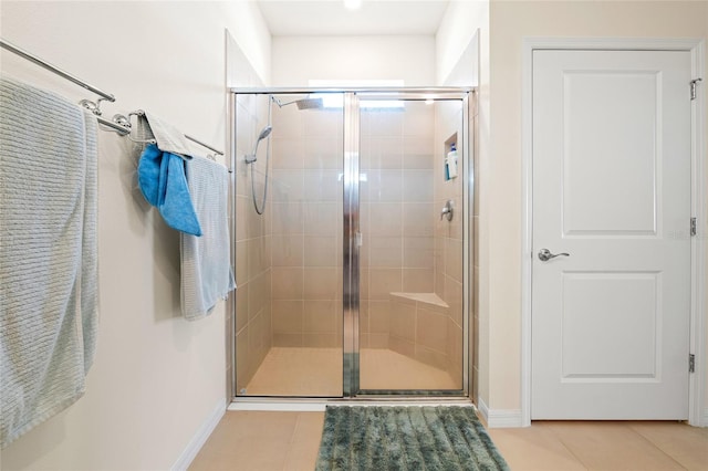 bathroom with tile patterned flooring and walk in shower