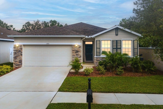 11892 Frost Aster Dr, Riverview, FL 33579 - ranch-style house with stone siding, concrete driveway, an attached garage, and stucco siding