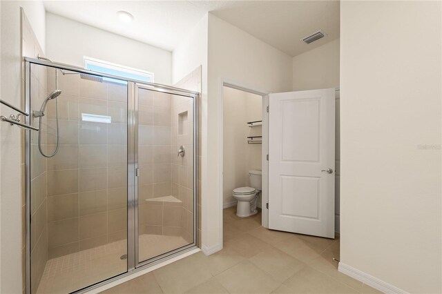 11892 Frost Aster Dr, Riverview, FL 33579 - bathroom featuring toilet, a stall shower, tile patterned flooring, and baseboards