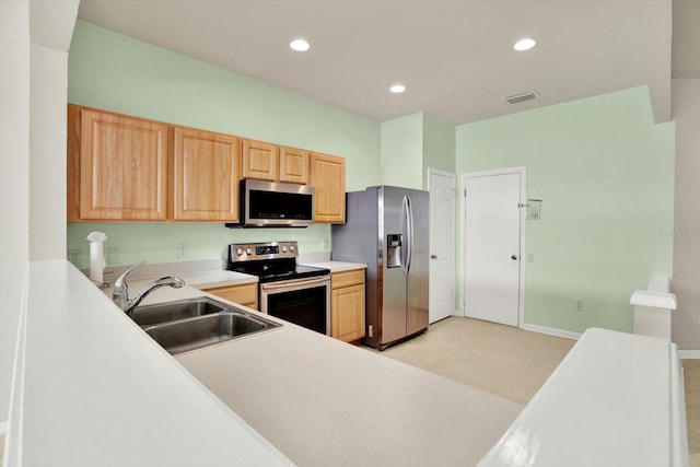 kitchen with light brown cabinets, stainless steel appliances, and sink