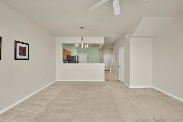 empty room with light carpet and ceiling fan with notable chandelier