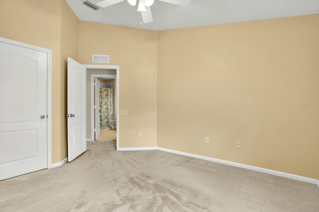 empty room featuring ceiling fan and light colored carpet