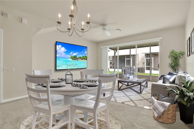 carpeted dining room featuring ceiling fan with notable chandelier