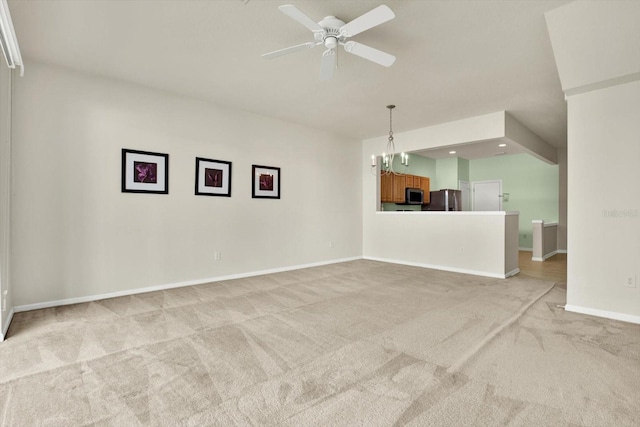 interior space with light colored carpet and ceiling fan with notable chandelier