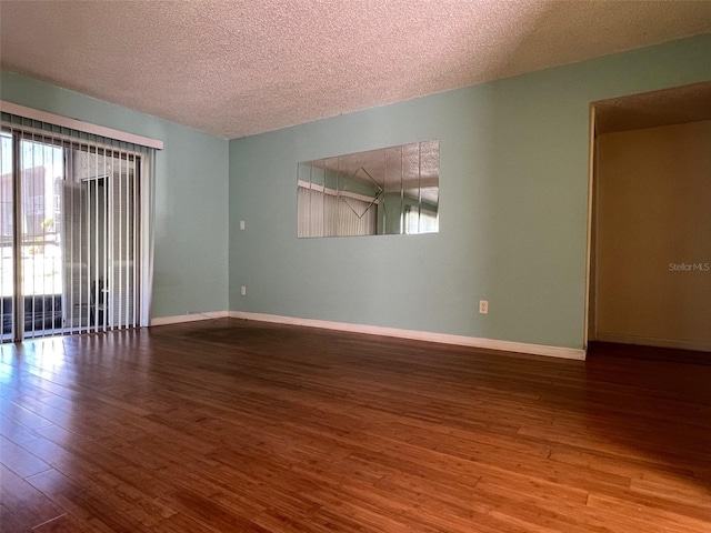 unfurnished room with wood-type flooring and a textured ceiling