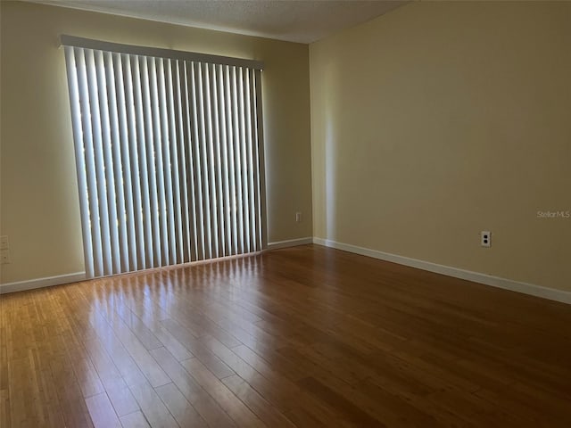 empty room featuring a textured ceiling and hardwood / wood-style floors