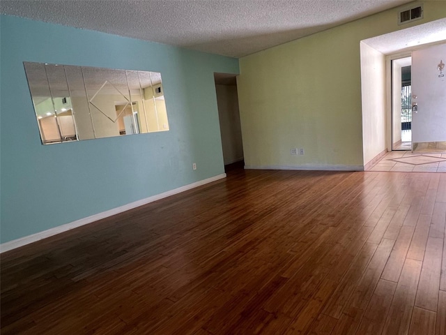 empty room featuring wood-type flooring and a textured ceiling