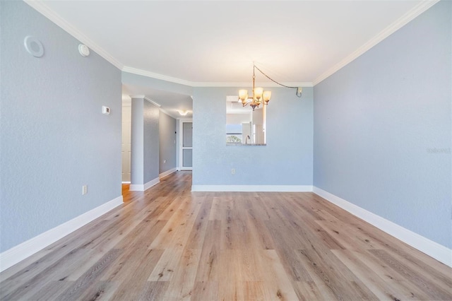 empty room featuring a notable chandelier, ornamental molding, and light wood-type flooring