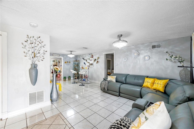 unfurnished living room with a textured ceiling and light tile patterned flooring