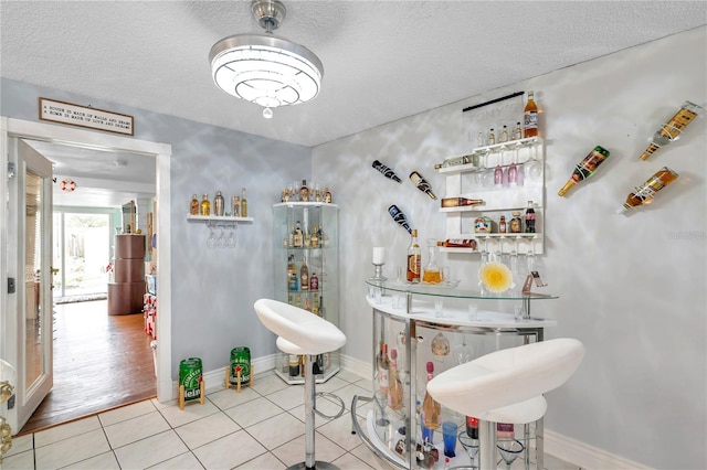 bathroom with a textured ceiling, water heater, and hardwood / wood-style flooring