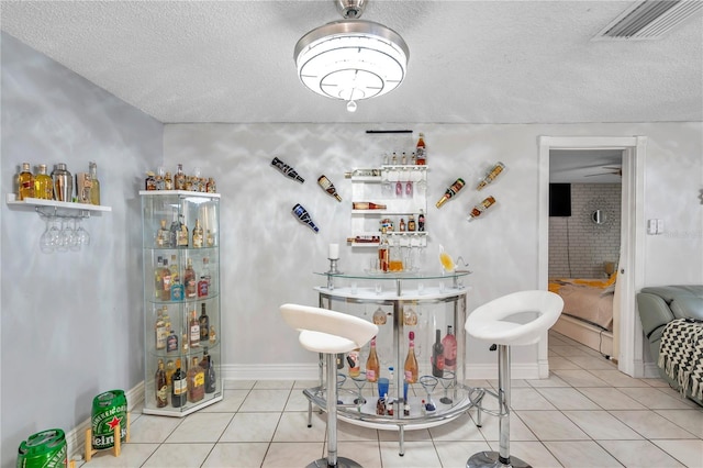 tiled dining space with a textured ceiling