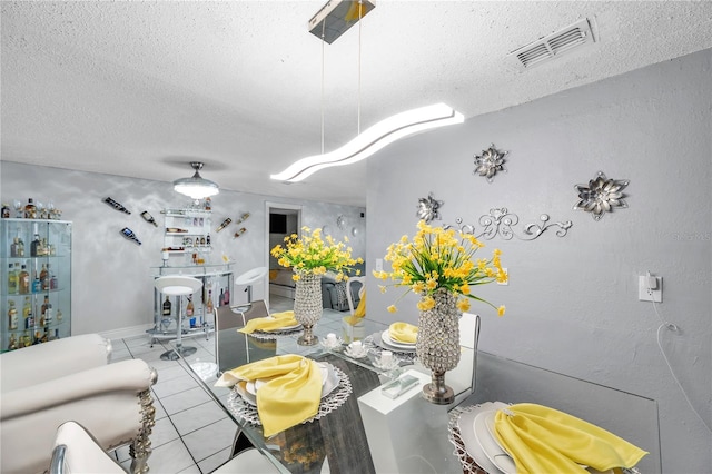 dining space featuring a textured ceiling and light tile patterned flooring