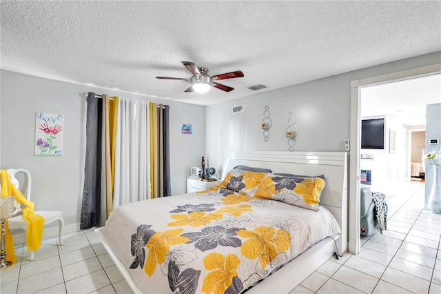 bedroom featuring a textured ceiling, light tile patterned floors, and ceiling fan