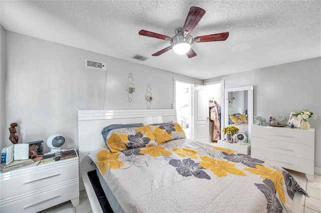 bedroom with ceiling fan, a textured ceiling, and light tile patterned floors