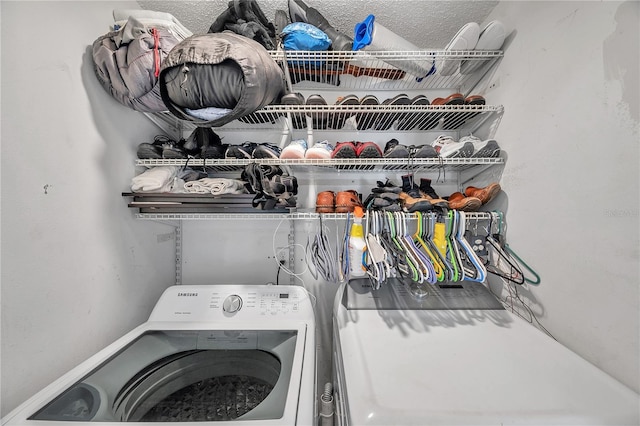 laundry room featuring washer / clothes dryer and a textured ceiling