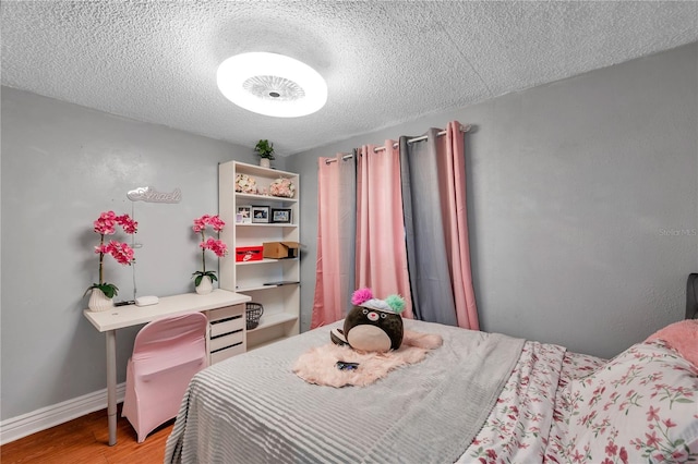 bedroom featuring a textured ceiling and hardwood / wood-style flooring