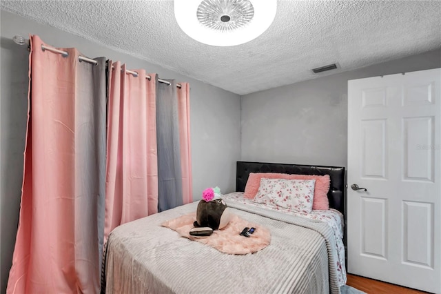 bedroom featuring wood-type flooring and a textured ceiling