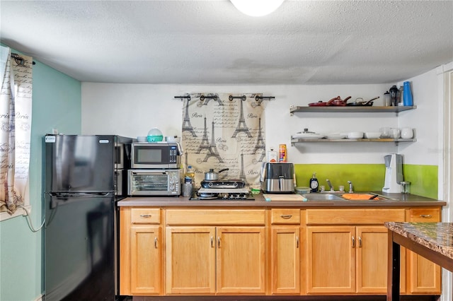 kitchen with a textured ceiling, stainless steel appliances, and sink