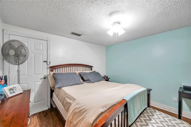 bedroom featuring a textured ceiling, ceiling fan, and light hardwood / wood-style flooring