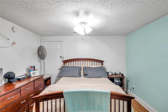 bedroom with a textured ceiling and hardwood / wood-style floors