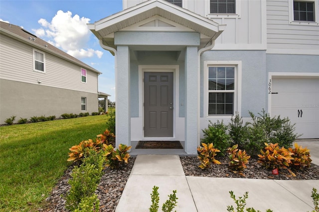 entrance to property with a lawn and a garage