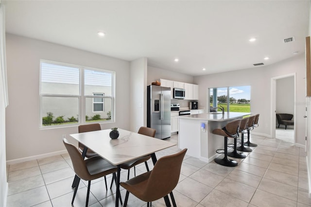 dining area featuring sink and light tile patterned floors