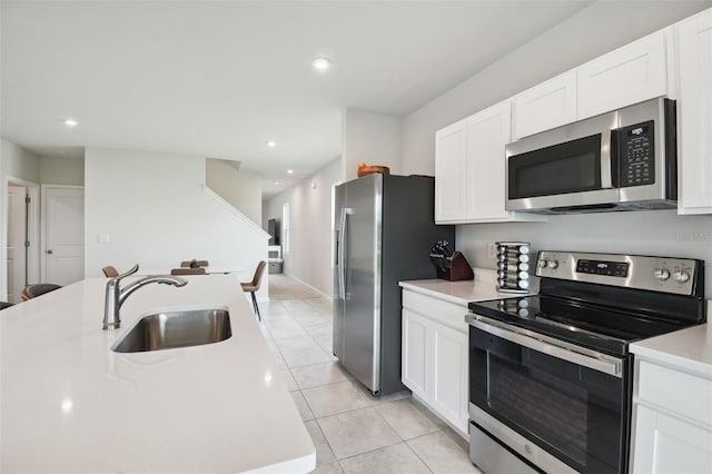 kitchen with white cabinetry, appliances with stainless steel finishes, sink, and light tile patterned flooring