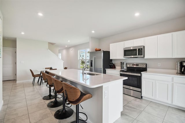 kitchen with sink, white cabinets, a kitchen island with sink, and stainless steel appliances