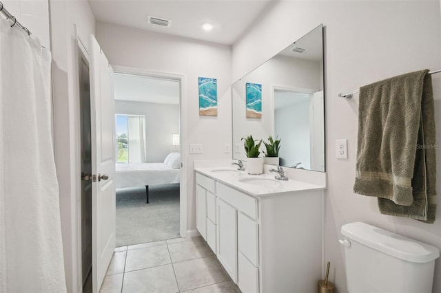 bathroom featuring vanity, tile patterned floors, and toilet