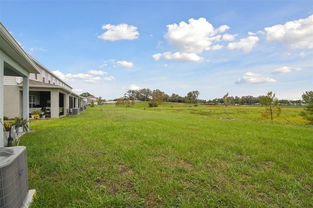 view of yard featuring central air condition unit and a rural view